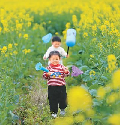 2月26日，湖南省永州市道县祥霖铺镇两河口村，小朋友在油菜花田里玩耍。 何红福摄（人民视觉）