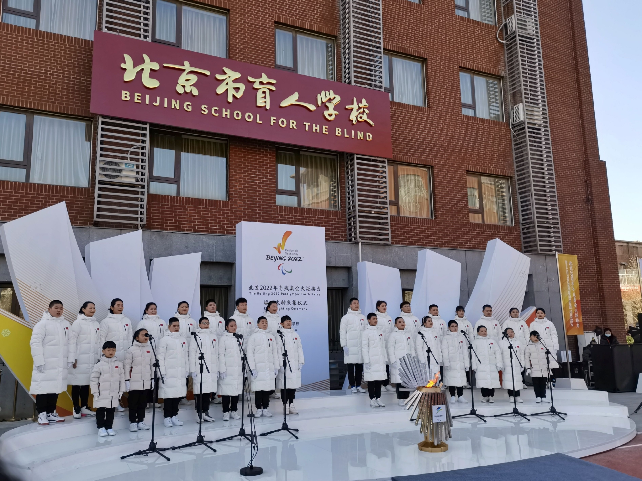 在北京盲人学校师生的歌声中,"光明之火"火种被引燃.