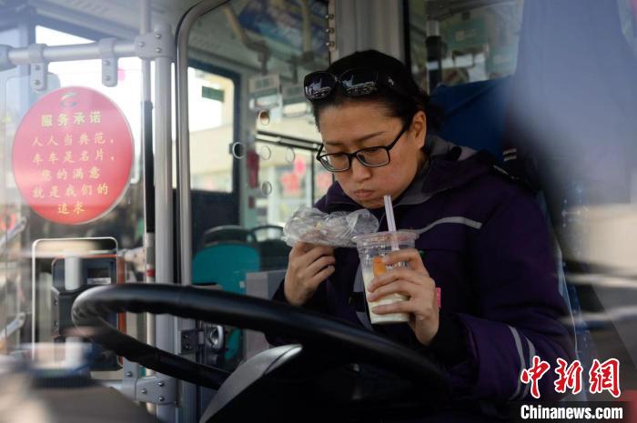 狼吞虎咽吃着包子,喝着豆浆的女公交车司机郭俊,正"享受"着她的早餐.