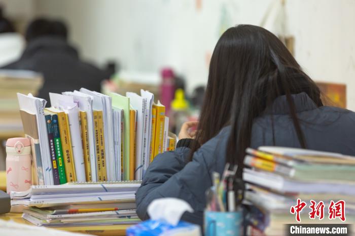 资料图：一名考生正在紧张复习，书桌上堆满了各类相关书籍。　刘力鑫 摄