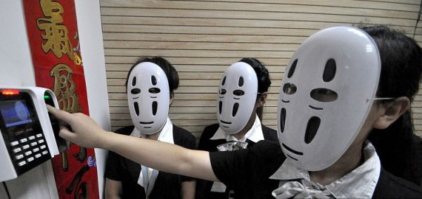 河北省邯郸市一家公司的员工戴面具工作，以放松心情释放压力。图为2015年7月14日公司员工戴着面具签到。（视觉中国）