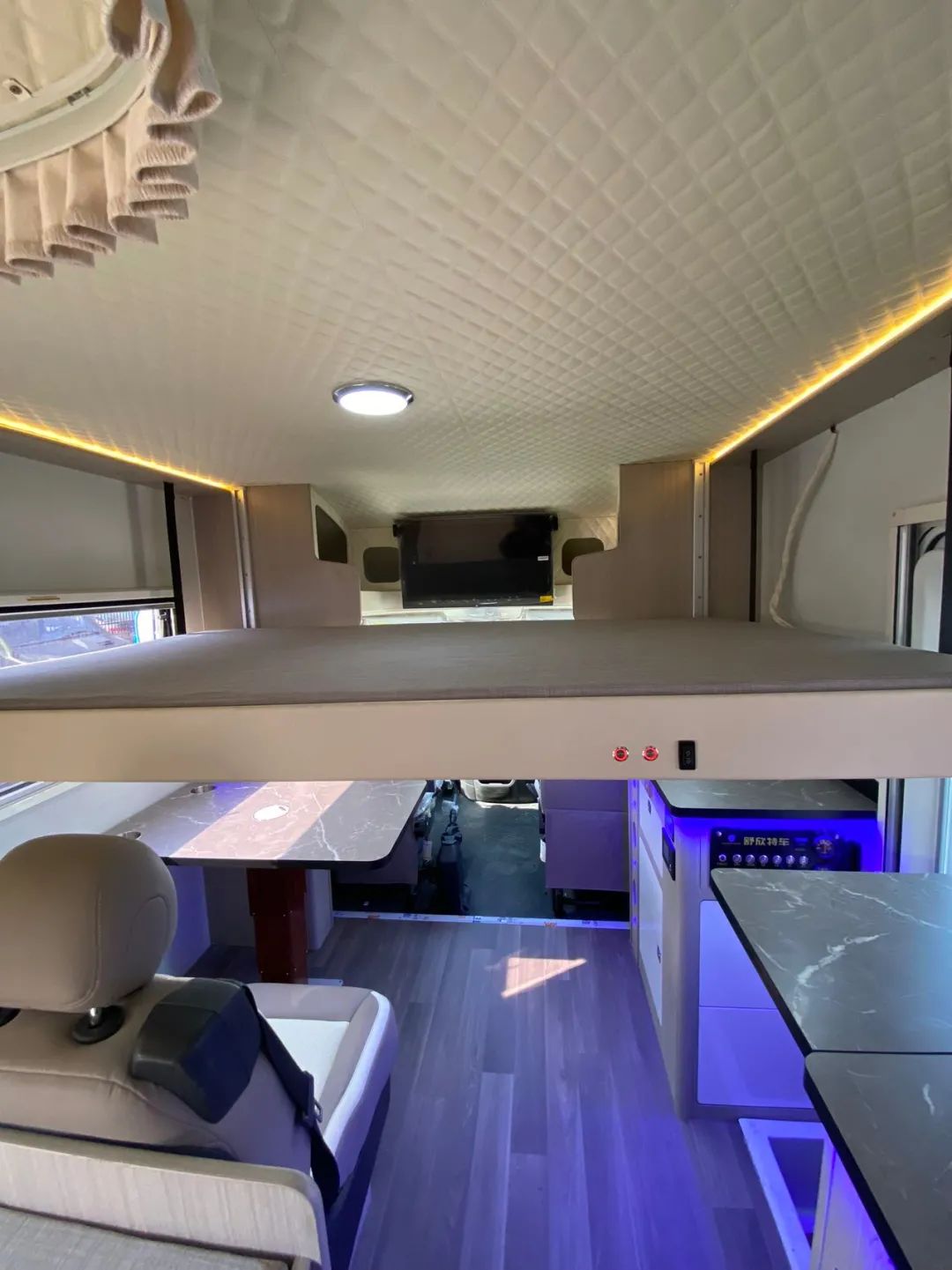 顶部则设计了横置的升降吊床,加上车尾部的纵床睡卧区为车友们一共