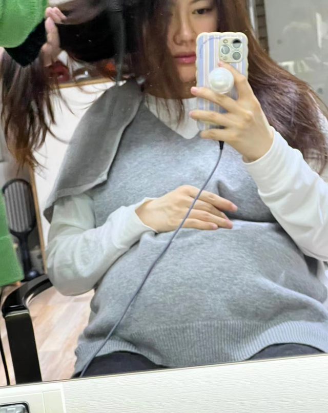 博谷调皮地对着镜头比心,她还灵机一动,把大肚子当成是手机支架,看