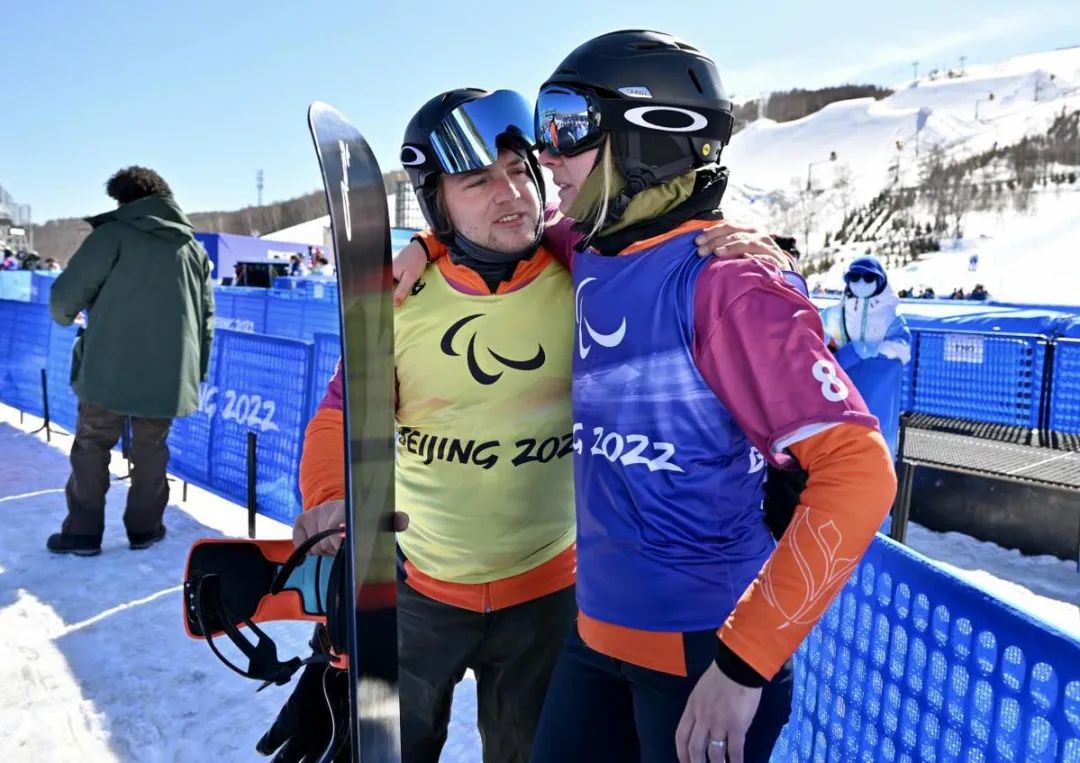 福斯（左）和莉萨在崇礼云顶滑雪公园完成男子和女子残奥单板滑雪比赛后互相鼓励。中国日报记者 魏晓昊 摄