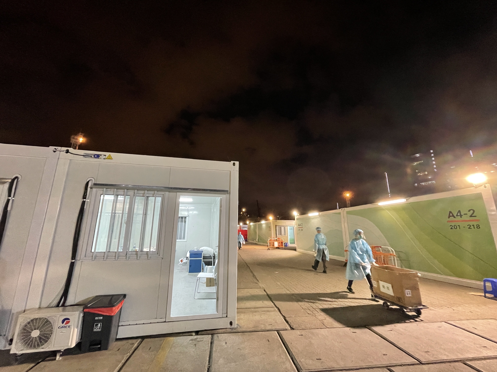 工作人员在夜间向隔离病房运送物资(3月12日摄,手机照片).