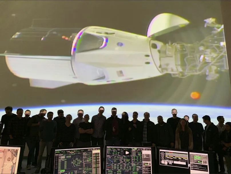 ▲2019年3月3日，在美国加利福尼亚州的霍索恩，工作人员观看大屏幕显示载人版“龙”飞船与国际空间站对接画面。图/新华社