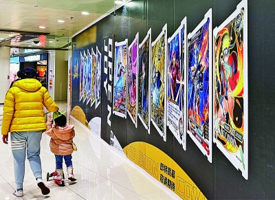 北京，家长带着孩子从卡牌连锁店广告前走过。光明图片/视觉中国