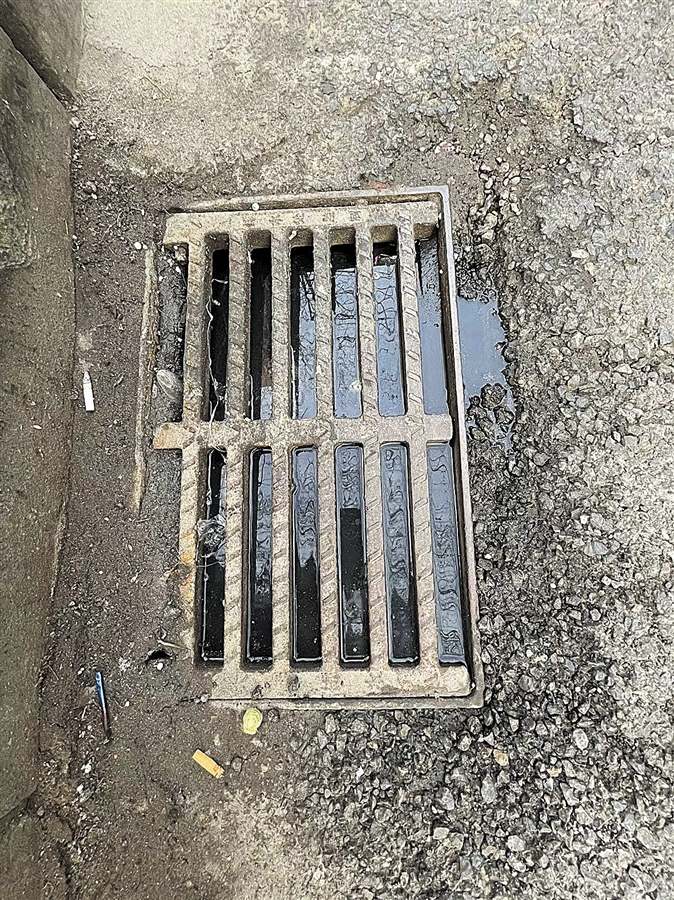 西岗区被淤泥杂物堵塞的雨水井.