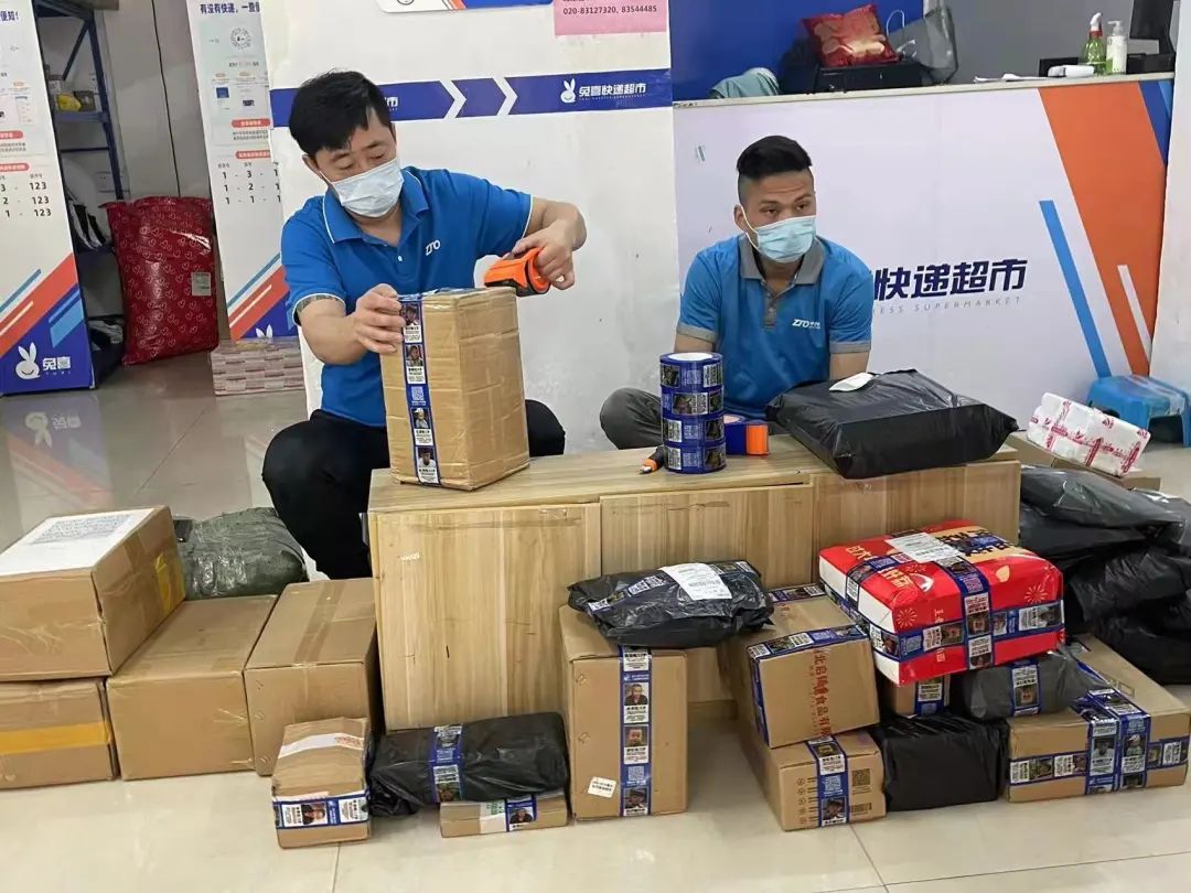 朱忠伟负责的网点内,快递员正在用寻亲胶带打包快递.受访者供图