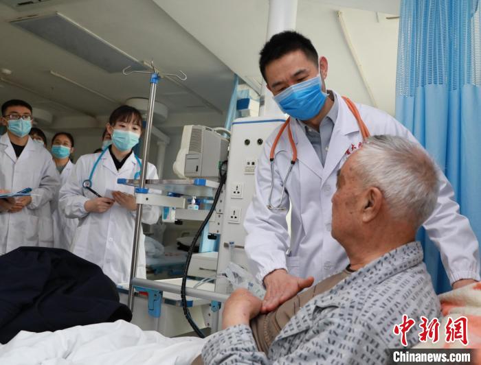 图为程康安(右)带领团队查房. 青海大学附属医院 供图