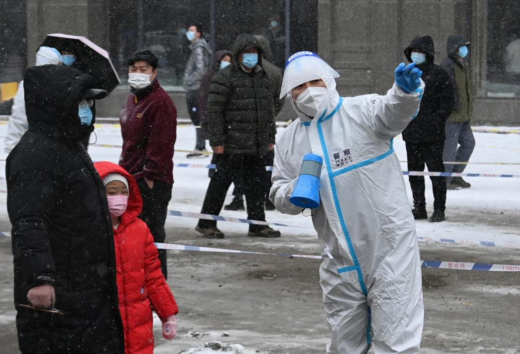 3月15日，长春市前进大街核酸检测点的工作人员向市民解释相关要求。新华社发（徐家军摄）