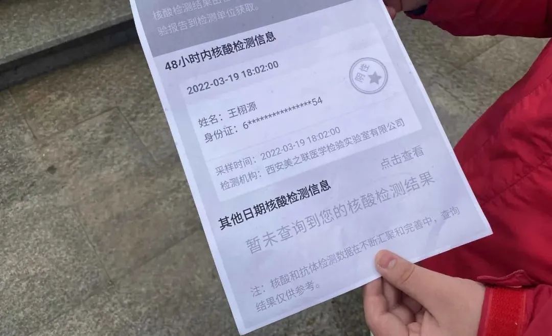 记者在西安市碑林区第二十六中学看到,学生们在出示核酸检测报告,测量