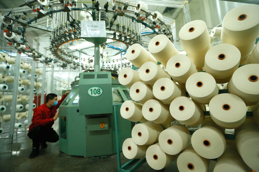 图为3月22日,在青岛市即墨区的青岛颐和针织有限公司,工人在生产服装