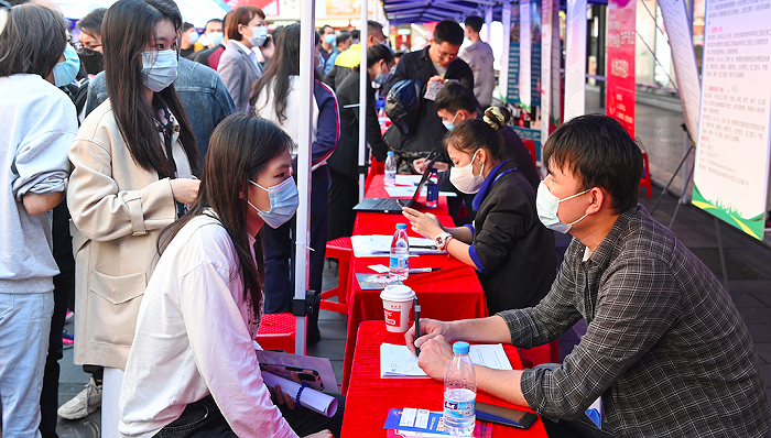 2022年2月11日,在海口市琼山区忠介路招聘会现场,求职者在应聘。图片来源:人民视觉