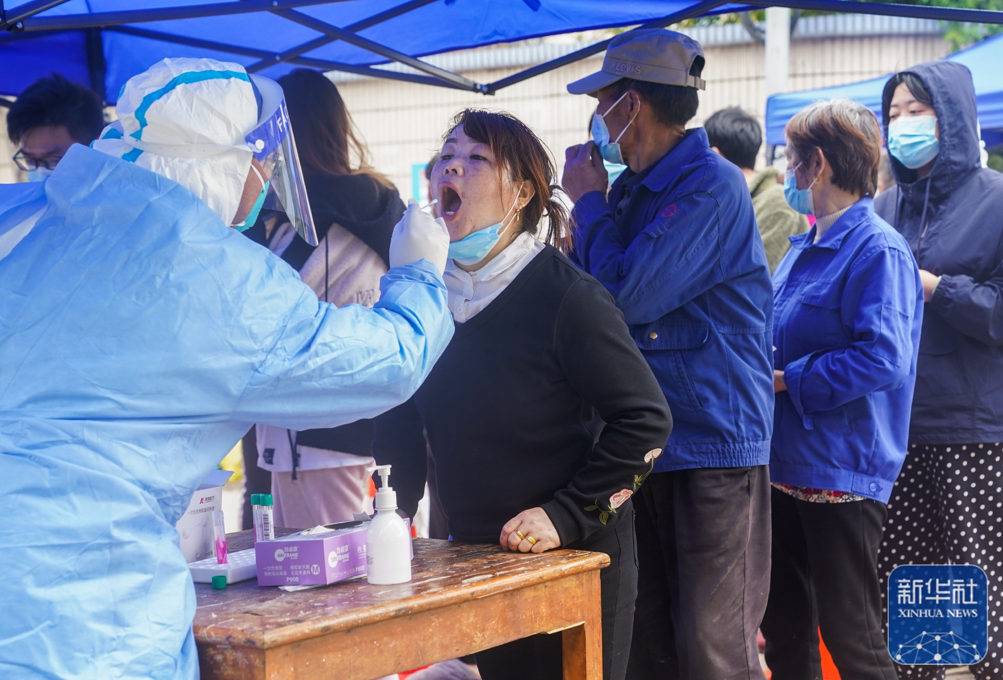 3月26日,在上海市浦东新区华中路上,市民排队进行核酸检测.