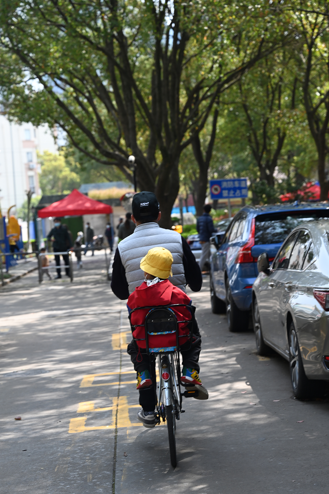 2022年3月23日,一位父亲骑车带着孩子在小区里绕圈兜风.