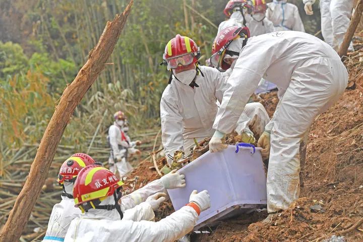 3月25日，搜救人员在事故核心现场搬运飞机残骸。新华社记者 周华摄