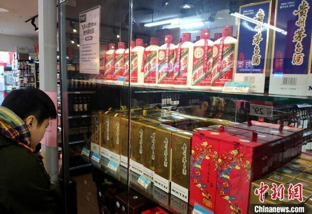 资料图：市民在福建福州的一超市贵州茅台酒专柜了解信息。中新社记者吕明摄