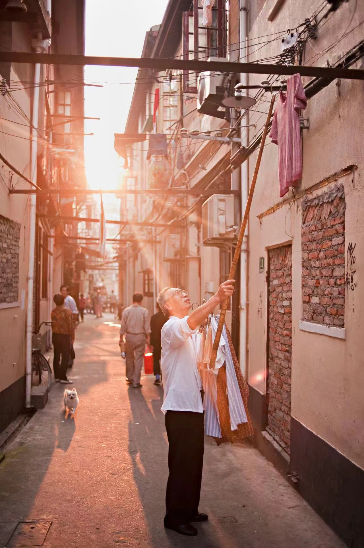 2011年10月7日,中国上海,一位老人拿下挂在弄堂上方的衣物.