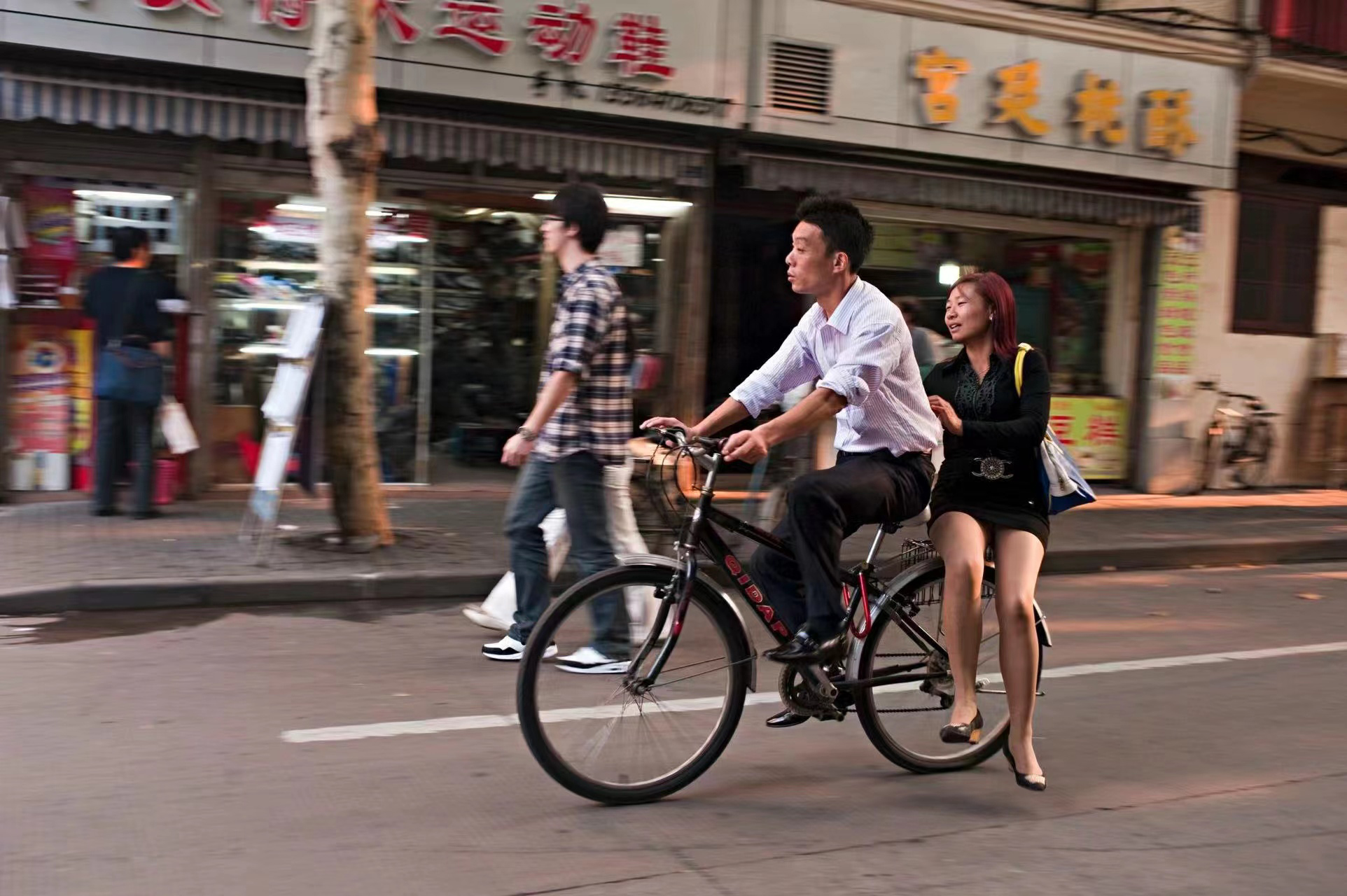 2011年10月7日,中国上海,一名年轻女子坐在自行车后座上.