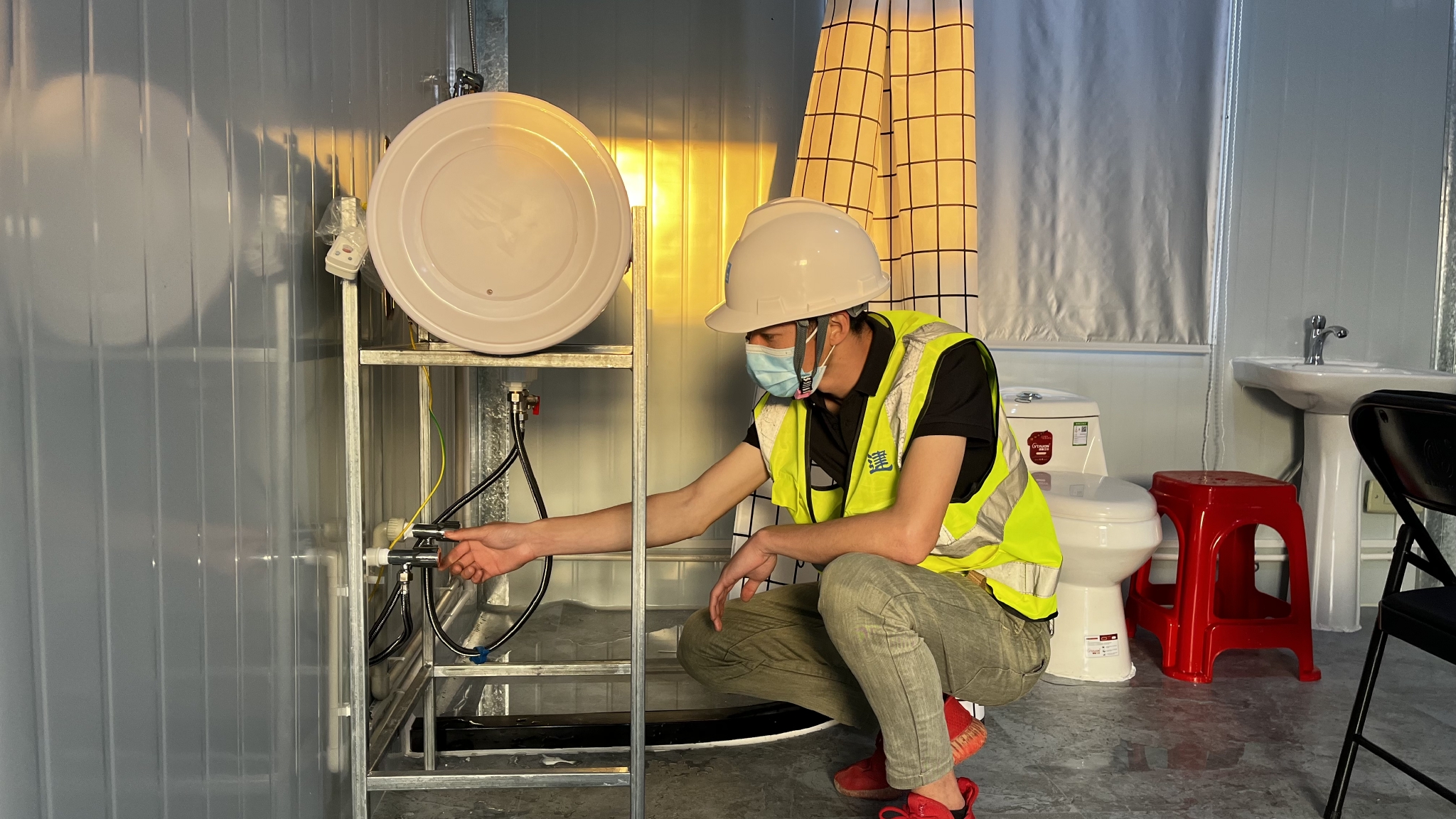 图片说明:中建三局三公司施工人员调试隔离房内设备
