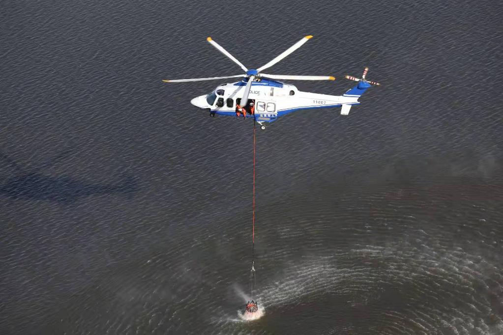 图为一架警用直升机在悬停过程中取水.北京市公安局供图