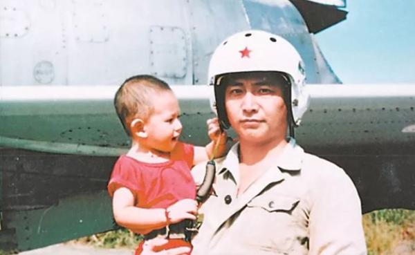 王伟抱着年幼的儿子在战机前合影。