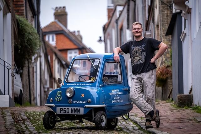 31岁的亚历克斯奥钦开着蓝色的小车peel p50在苏塞克斯村里闲逛,送信