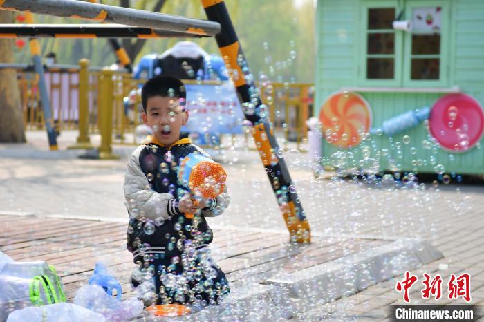 4月4日，小朋友在北京陶然亭公园玩泡泡枪。中新社记者 田雨昊 摄