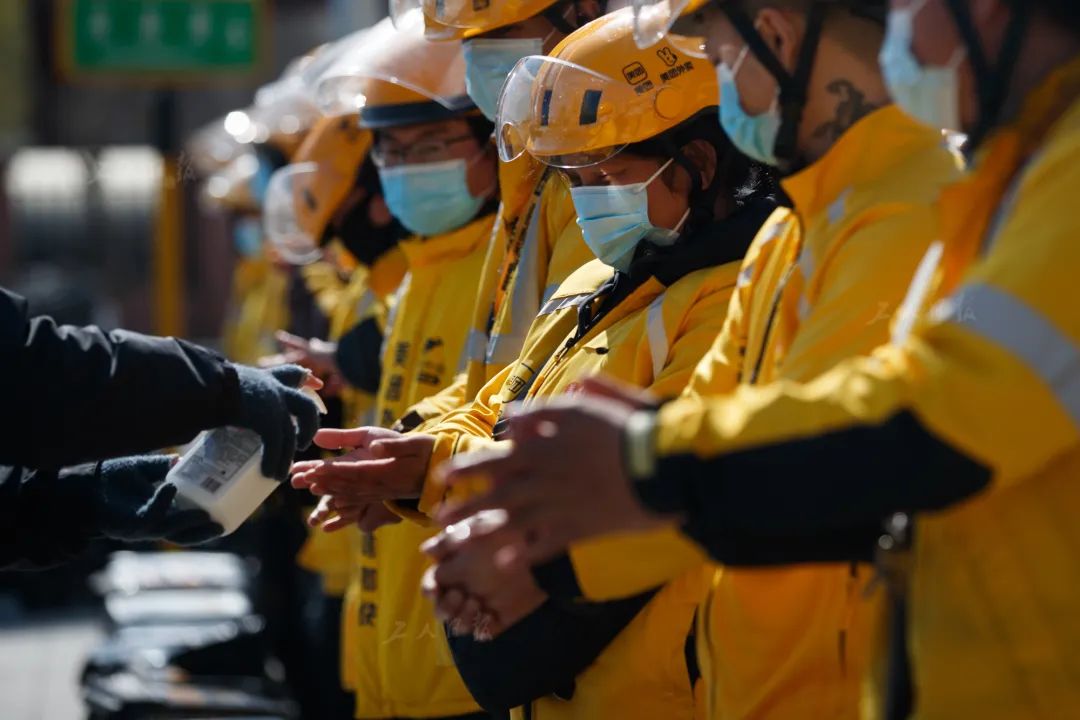 3月31日上午,在开完早会后,美团外卖站点的工作人员正为外卖送餐员