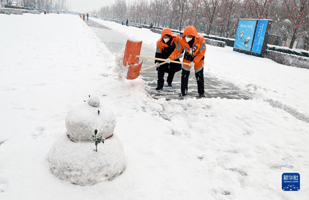 2022年2月13日，工作人员在北京冬奥会和冬残奥会主媒体中心外清扫积雪。新华社记者 武巍 摄