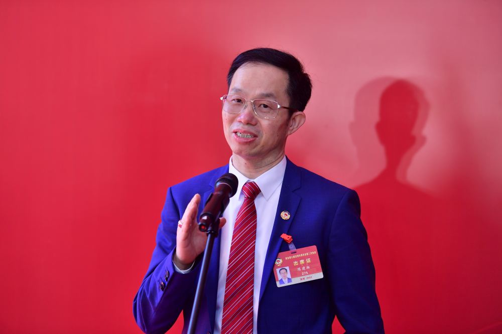 图为会后首场"委员通道"记者采访活动,深圳政协委员陈建湘接受记者