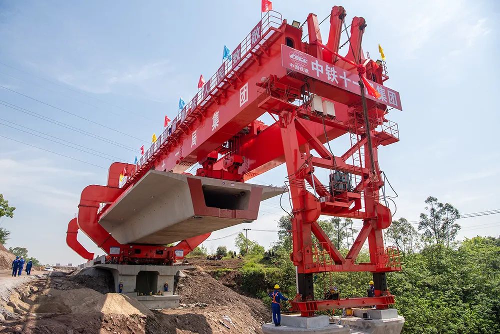 4月8日,在渝昆高铁重庆段建设现场,架桥机在进行首榀箱梁架设作业.