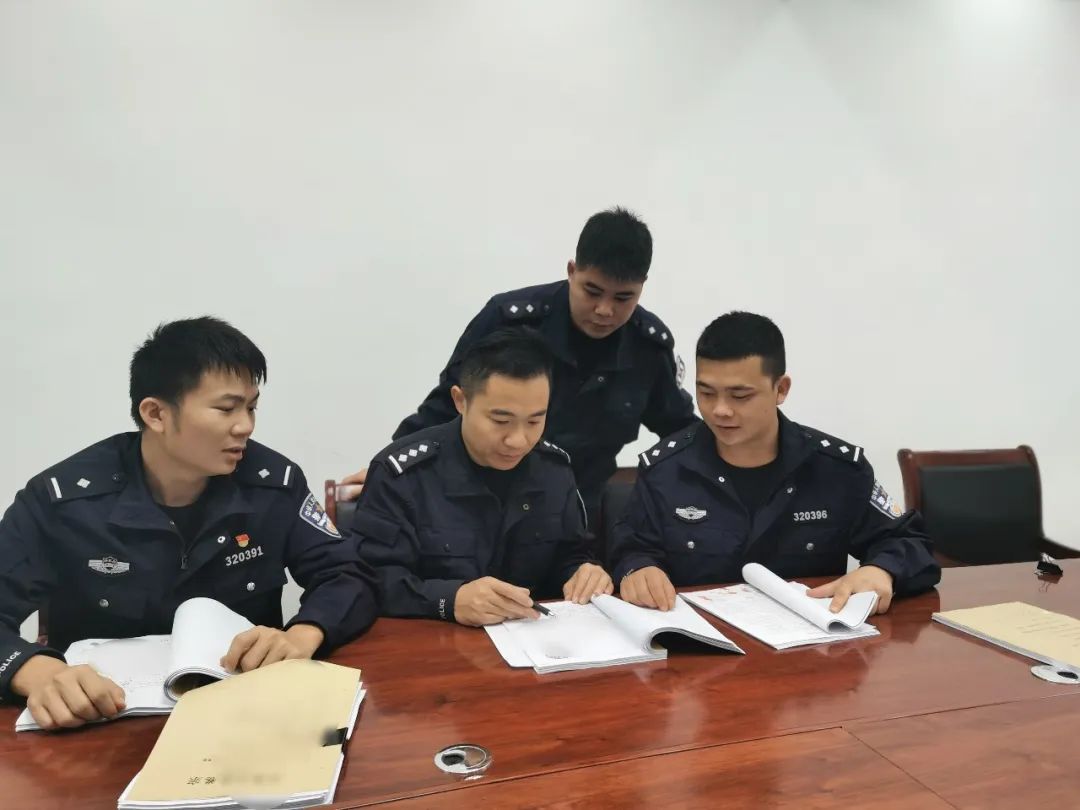 图为移民管理警察分析讨论案情.