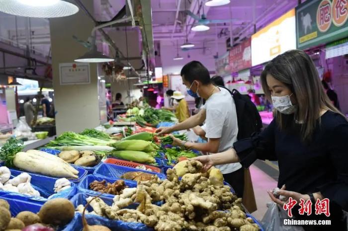 图为广州市民在一菜市场选购蔬菜。中新社记者 陈楚红 摄