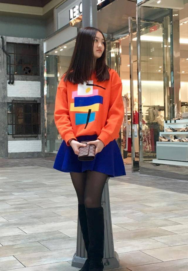 橙黄色的卫衣看上去简单却又很时髦,不过陆子艺脚上这双黑色长靴,却