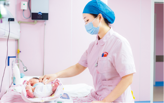 4 月,攀枝花妇幼保健院的护士给婴儿称量体重(石磊/ 摄)