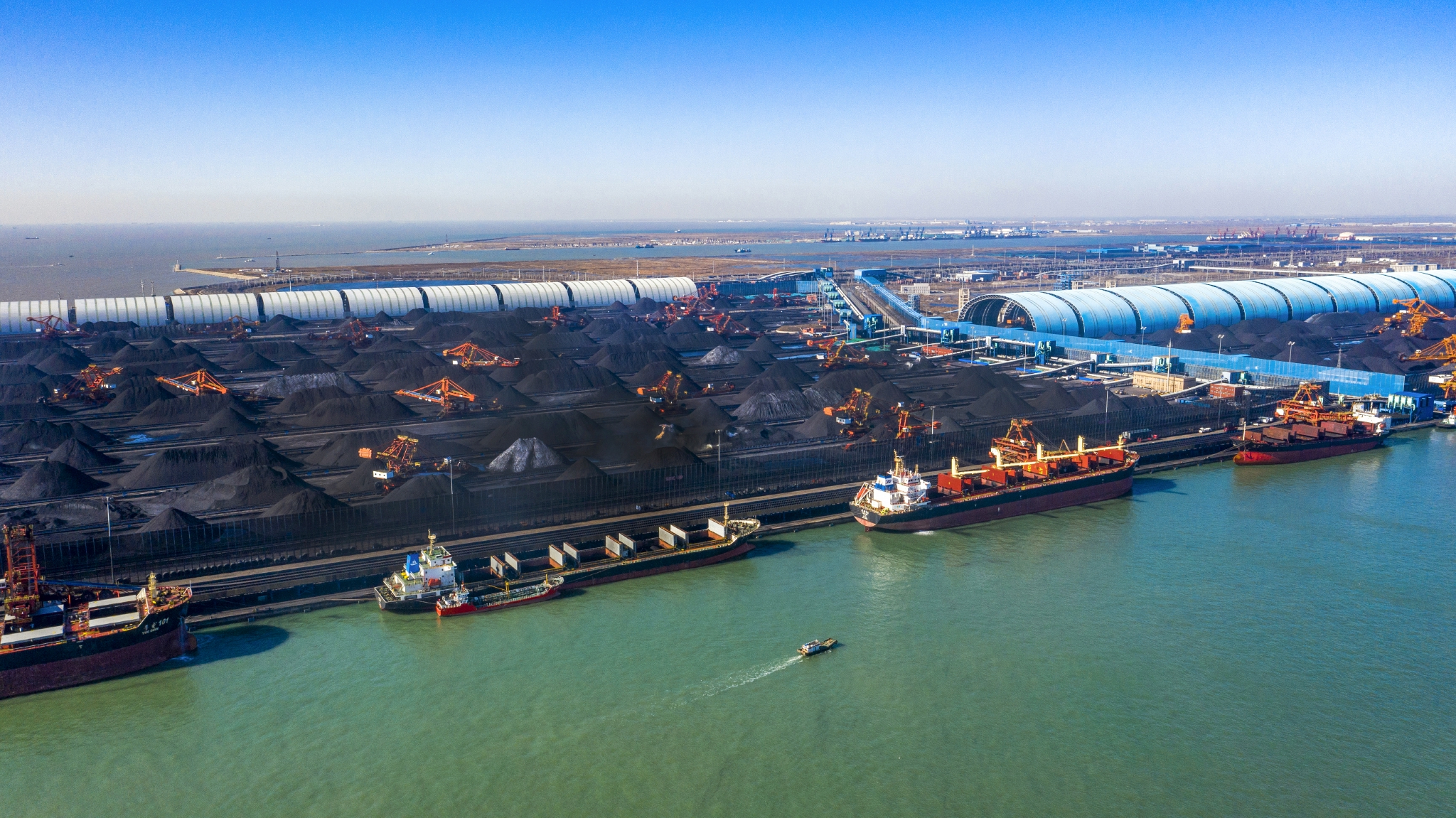 4月12日,多辆大型船舶在曹妃甸港区煤码头接卸煤炭.