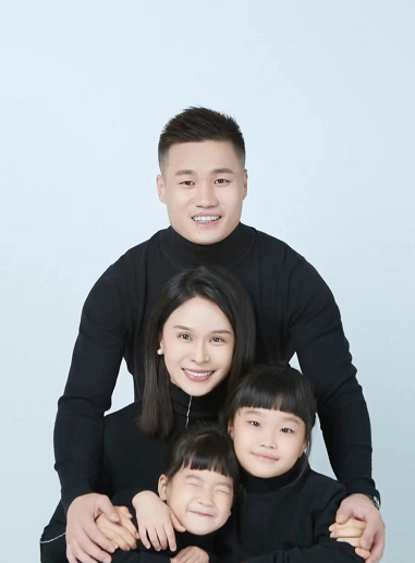 照片中,吕小军环抱着妻子和两个女儿,一家四口笑意盈盈,幸福感要溢出