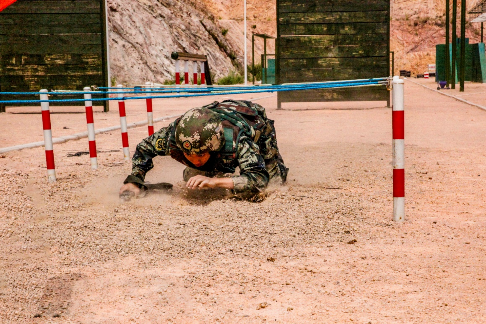 图为参赛官兵匍匐通过低桩网.黄泽聪 摄