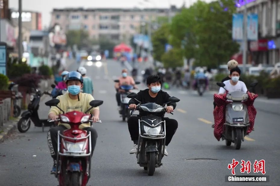 4月11日，上海金山区枫泾镇，居民骑电动车出行。中新社记者 田雨昊 摄
