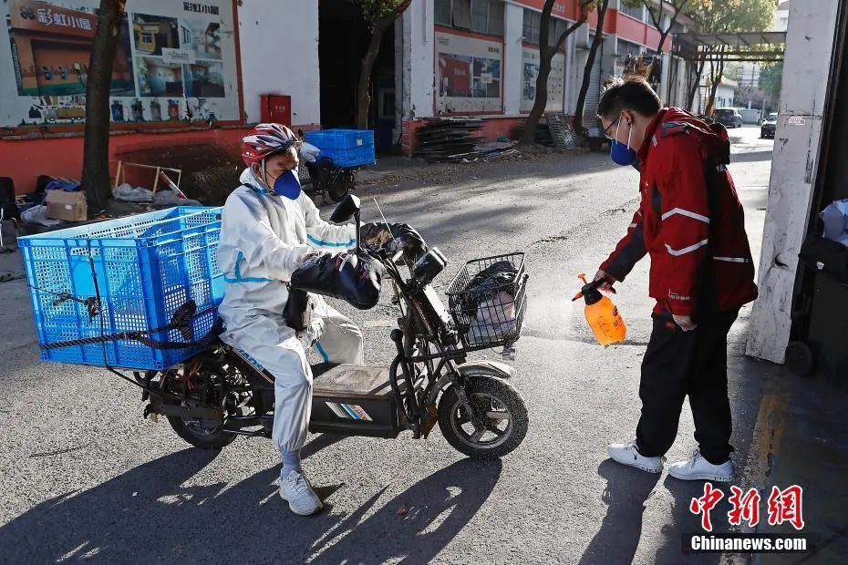 快递人员正在对回来的电动自行车进行消毒作业。中新社记者 殷立勤 摄