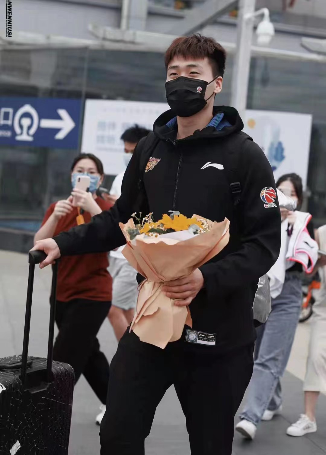 趙睿手捧鮮花推拉桿箱女球迷拿手機拍照保持距離緊緊跟隨