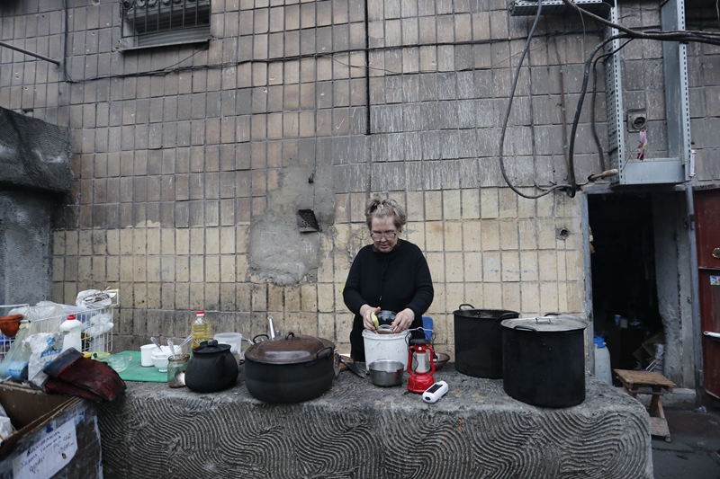　　↑4月14日，马里乌波尔当地居民在室外洗碗。新华社发（维克托 摄）