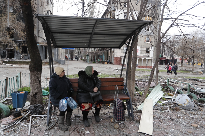 　　↑4月14日，马里乌波尔当地居民坐在长椅上张望。新华社发（维克托 摄）