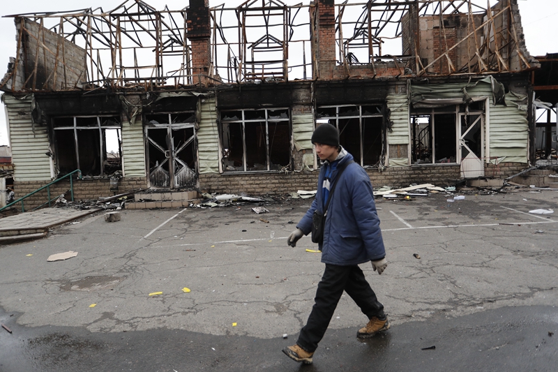 　　↑4月14日，马里乌波尔当地居民从被损坏的建筑旁走过。新华社发（维克托 摄）