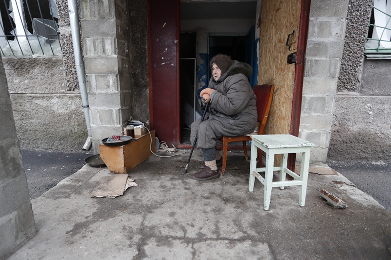 　　↑4月14日，马里乌波尔当地居民坐在被损坏的建筑旁。新华社发（维克托 摄）
