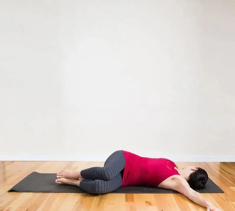 右手指尖双腿向左,头部右转,双手侧平举向两侧打开,掌心向下仰卧垫上