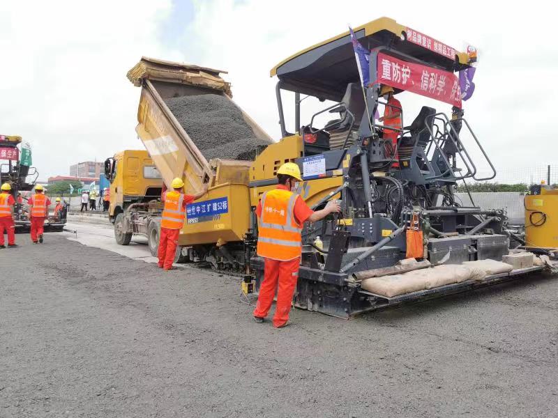 摊铺机呈梯队式稳步摊铺水泥稳定碎石底基层.陶莉 摄