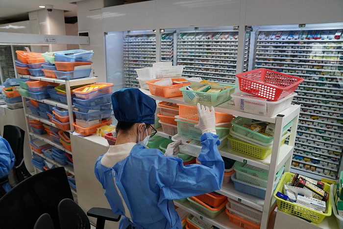 在同仁医院药房,一名工作人员按照用药需求单配药.